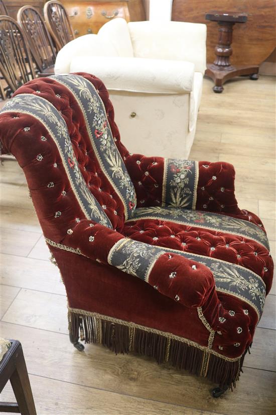 A late Victorian button back ebonised easy armchair